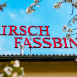 TEKUTÉ POKLADY S CHUTĚMI LÉTA. FASSBIND – nejstarší švýcarská palírna mezi jezery a horami Poutač slavné palírny Fassbind